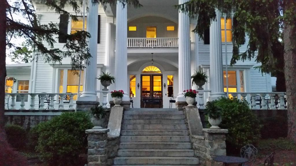 a large white house with stairs in front of it at Albemarle Inn - Asheville in Asheville