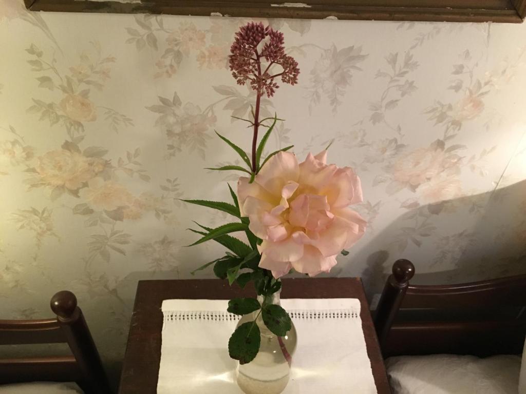 un jarrón con flores en una mesa en Berte Bed&Breakfast, en Slöinge
