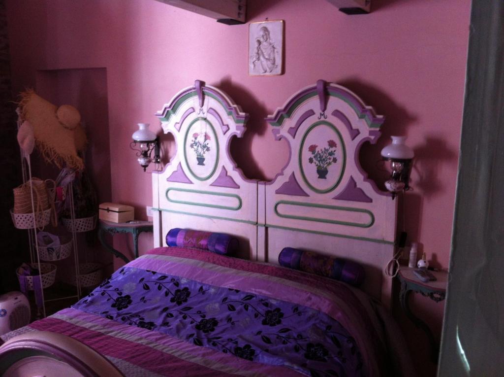 ジェンマーノにあるAntico mulino Gemmanoのピンクのベッドルーム(白いヘッドボード付きのベッド1台付)