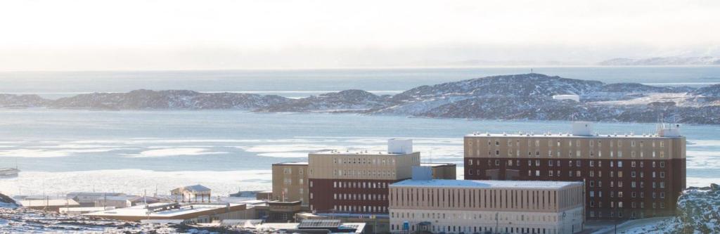 an aerial view of a city with mountains and the ocean at The Frobisher Inn in Iqaluit