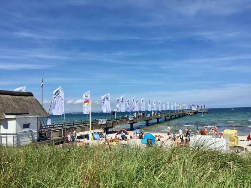 a pier with a bunch of people on the beach at Haus am Heidebeck in Scharbeutz