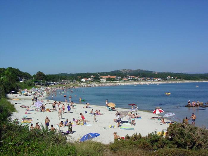 duża grupa ludzi na plaży w obiekcie Apartamentos Luis Antonio Mestre w mieście O Grove