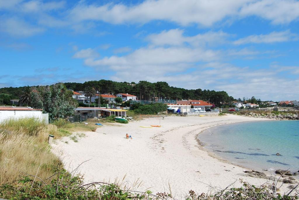 plaża z ludźmi na piasku i wodzie w obiekcie Apartamentos Luis Antonio Mestre w mieście O Grove