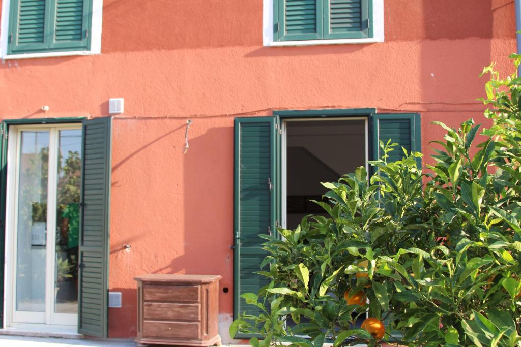 a building with green shutters and an open door at Aeroporto Bellini Rooms in Catania