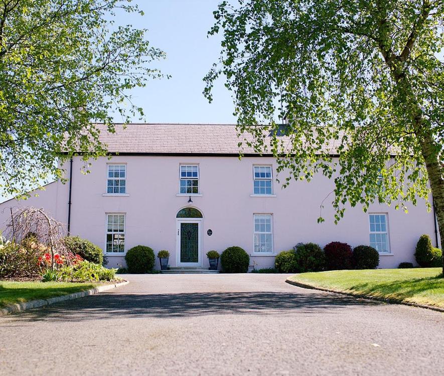 una casa blanca con una entrada delante de ella en Cavan House, en Rathfriland