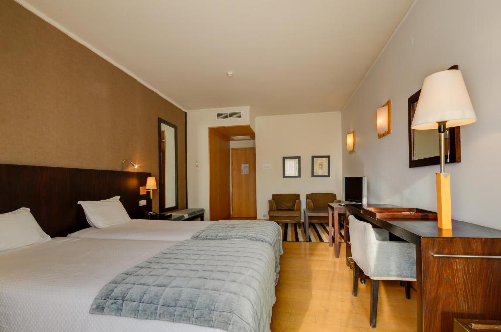 a hotel room with a bed and a desk at Hotel Alvorada in Estoril