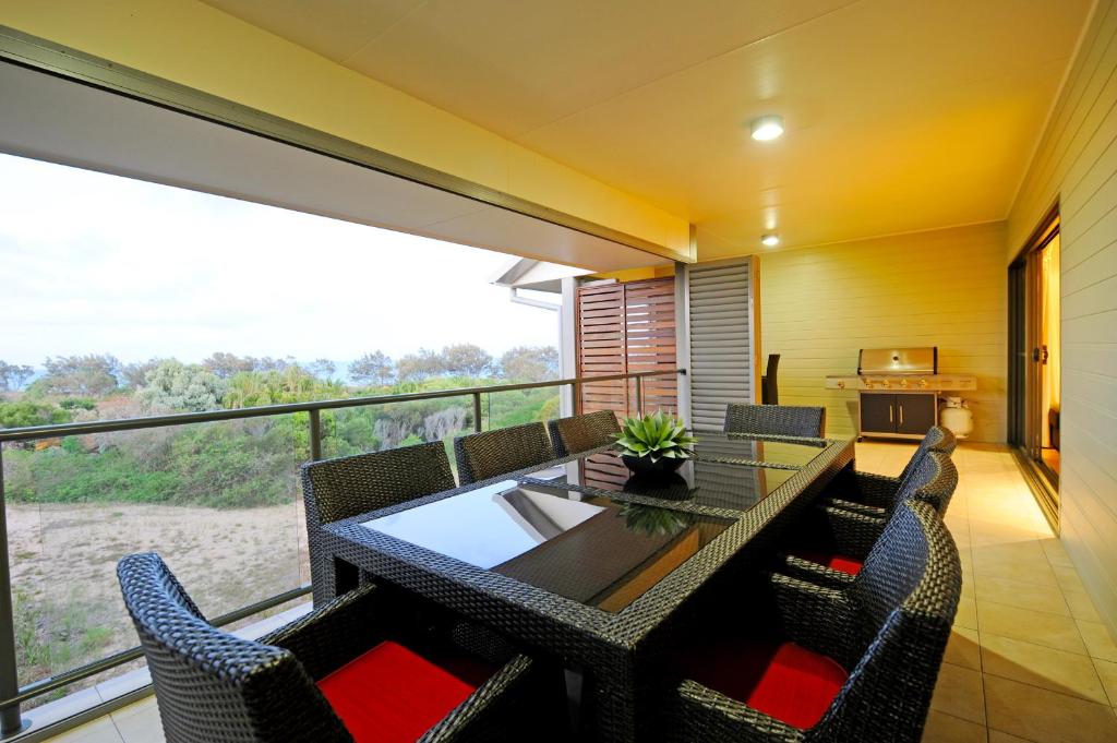 uma sala de jantar com uma mesa e cadeiras numa varanda em Loka Santi 14 - Beachfront penthouse with sea view em Agnes Water