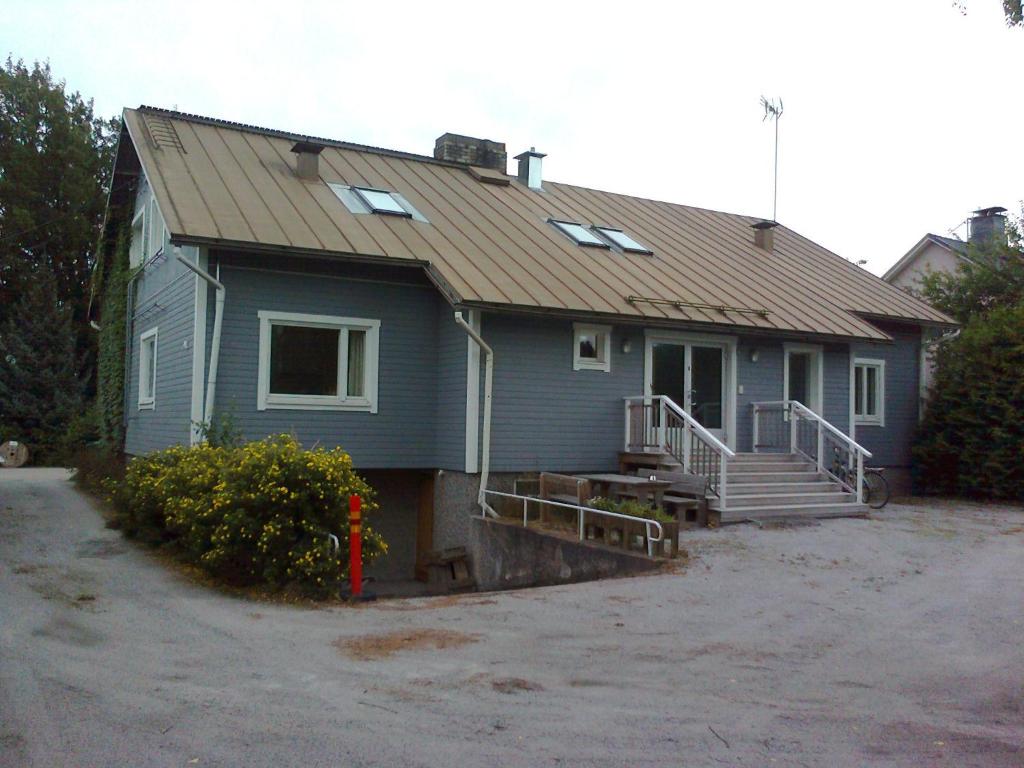 une maison bleue avec un toit en métal dans l'établissement Marent Apartments, à Salo