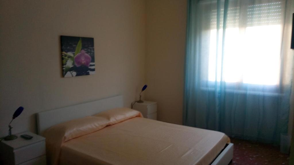 um pequeno quarto com uma cama e uma janela em lovelybed em Aprilia