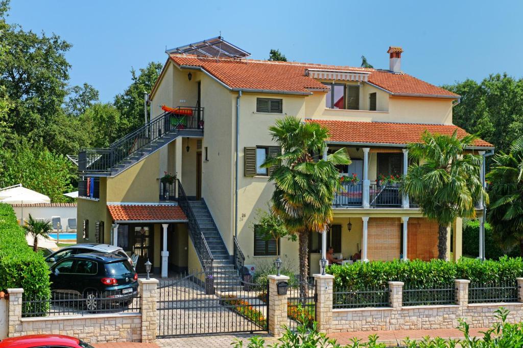 Rošini的住宿－Apartments Pilic，前面有停车位的房子