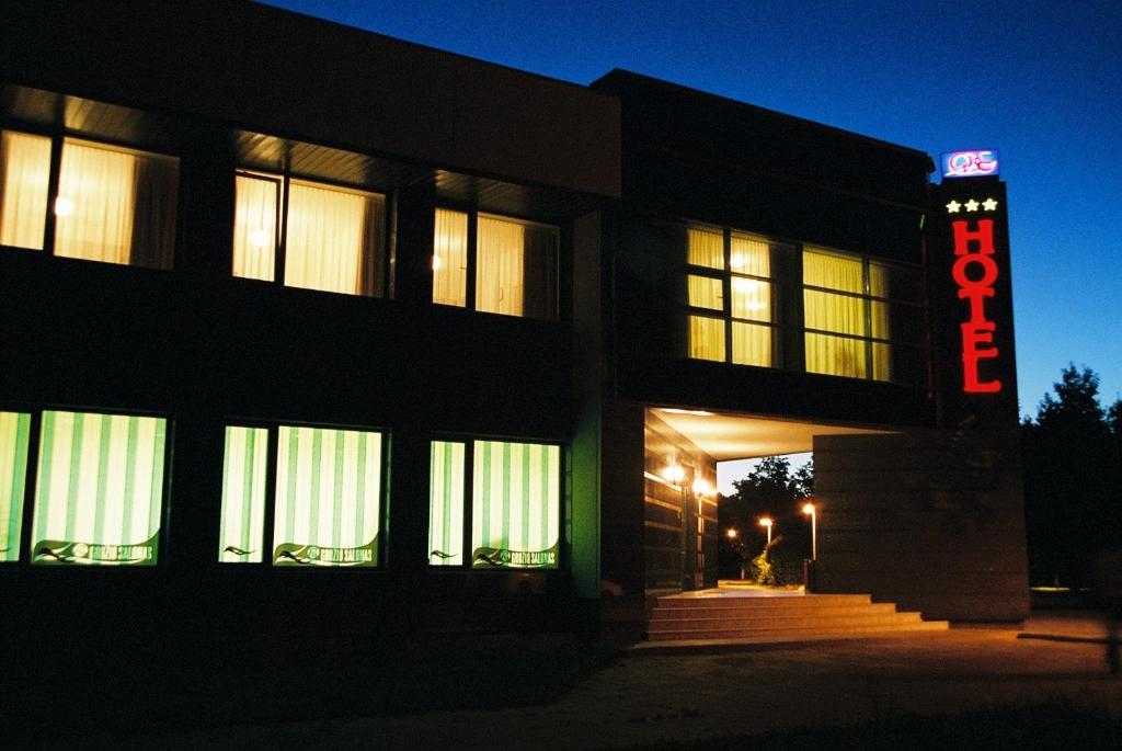 a building with a neon sign in front of it at Hotel Ode in Alytus