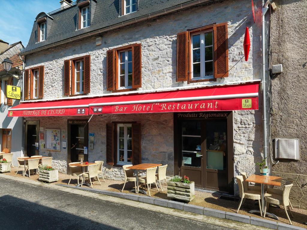a restaurant with tables and chairs outside of a building at Logis Auberge de l'Isard in Saint-Lary