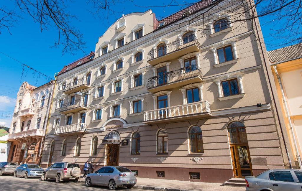 un gran edificio con coches estacionados frente a él en Stanislaviv, en Ivano-Frankivsk