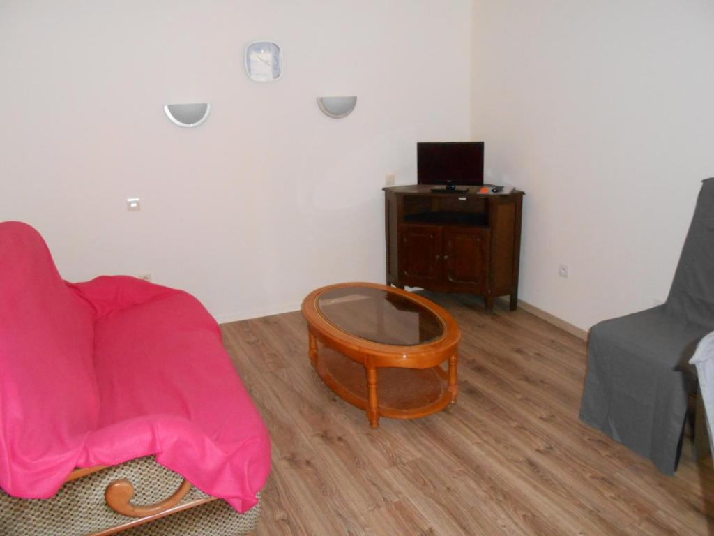 Habitación con sofá y mesa con espejo. en Appartement, en Château-Renault
