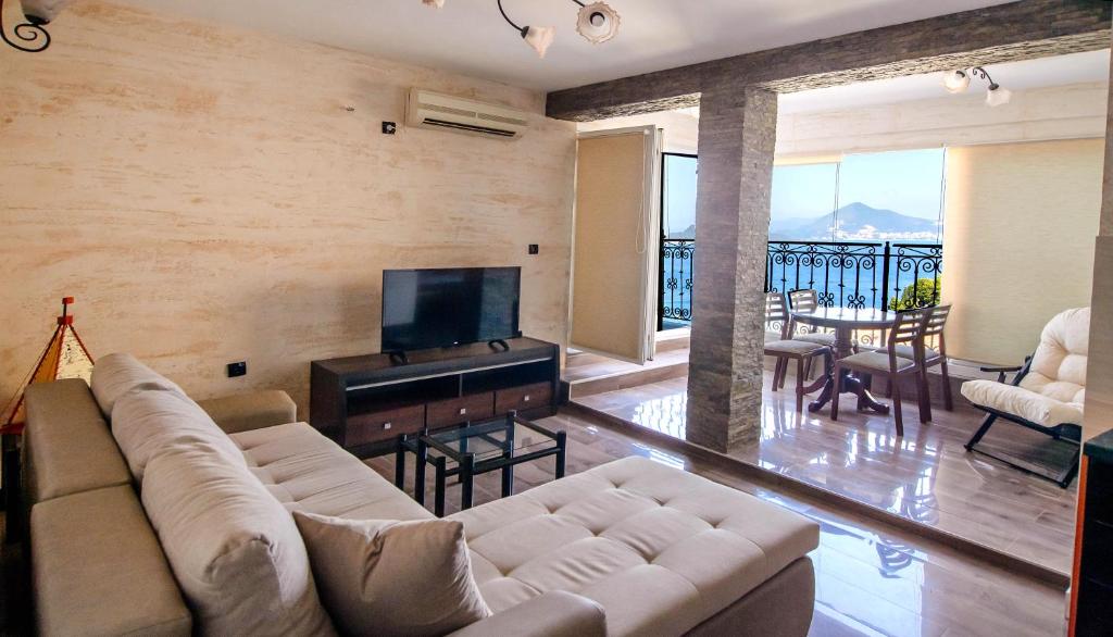 a living room with a couch and a flat screen tv at Apartment Dzaleta in Sveti Stefan