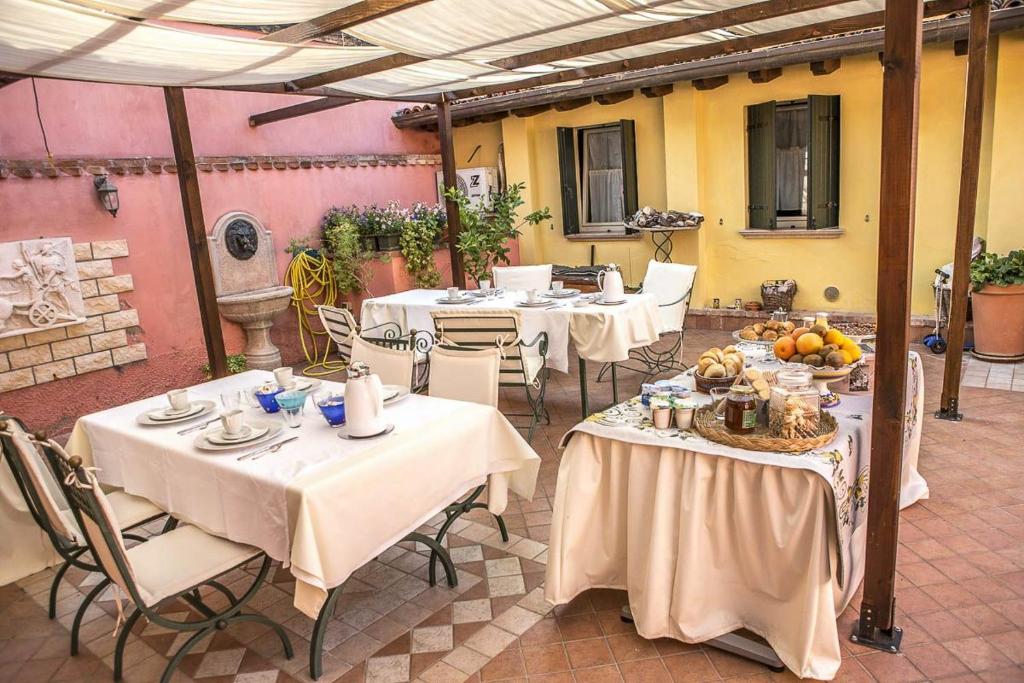 un patio con mesas y sillas con comida. en Ca' Noemi, en Lido de Venecia