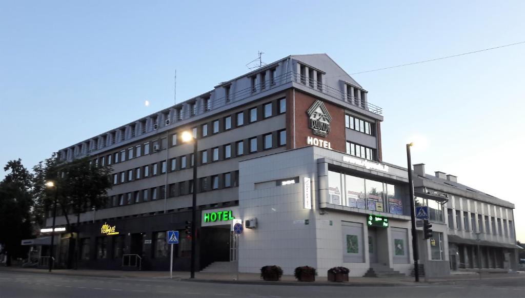 a building with a clock on the side of it at Dzukija Hotel in Alytus