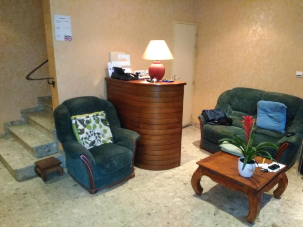 a living room with two chairs and a table at Hotel Lou Cantou in Chanac