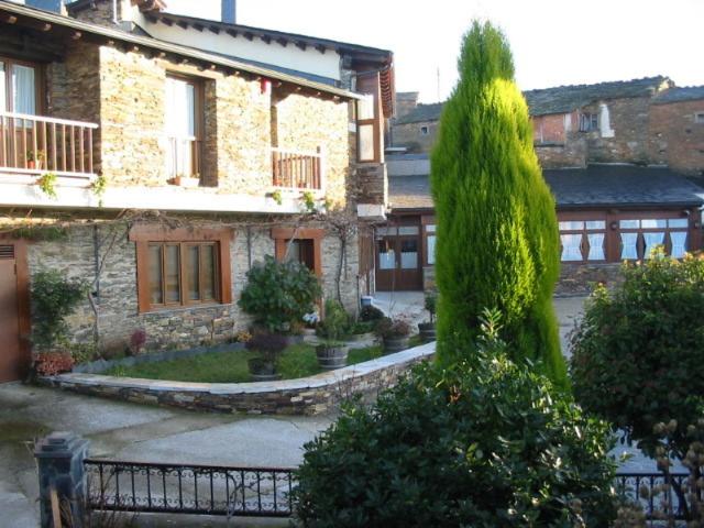 a large green tree in front of a building at Hotel O Forno in Salcedo