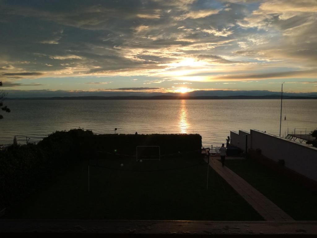 zachód słońca nad wodą i zachodem słońca w obiekcie Sunset Beach Apartmanház w mieście Balatonvilágos
