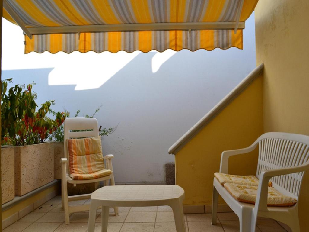 a balcony with a table and a chair and a window at Casa Vacanze Manila in Marina di Mancaversa
