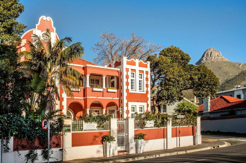 a orange building with a mountain in the background at The Villa Rosa Guest House & Self-catering Apartments in Cape Town