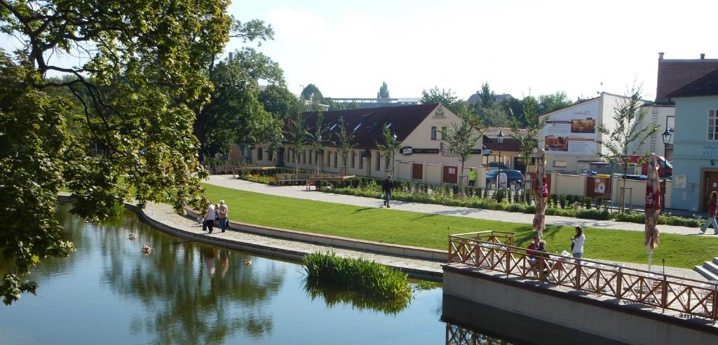 Eine Gruppe von Menschen, die auf einer Brücke über einen Fluss laufen in der Unterkunft Hotel Green Gondola in Pilsen