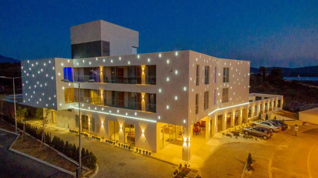 un grande edificio bianco con luci accese di notte di Kosher Hotel Franca a Tivat