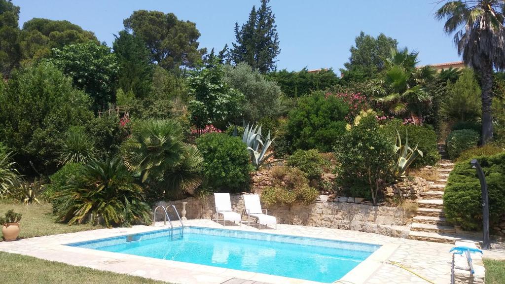 una piscina en un jardín con árboles en Villa Le Clos Fleuri, en Narbona