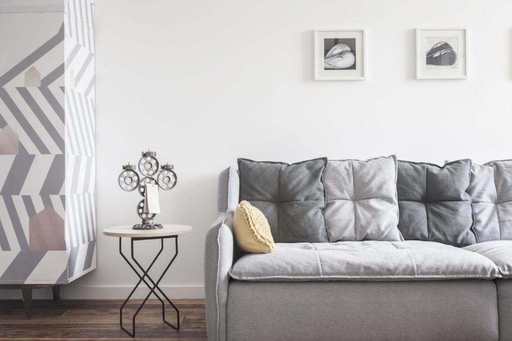 un divano grigio in un soggiorno con tavolo di Apartament BM a Danzica