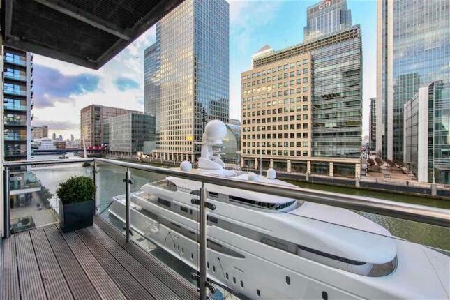 倫敦的住宿－NY-LON Corporate Apartments，河上建有建筑物的船只阳台