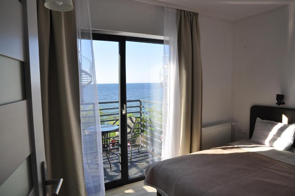 a bedroom with a bed and a view of the ocean at Dom Przy Plaży in Ustronie Morskie