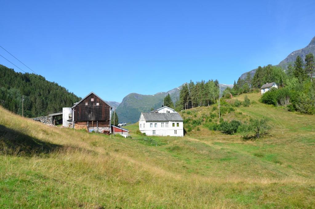 un grupo de casas en una colina en un campo en Tunold Gård - Gamle huset, en Mindresunde