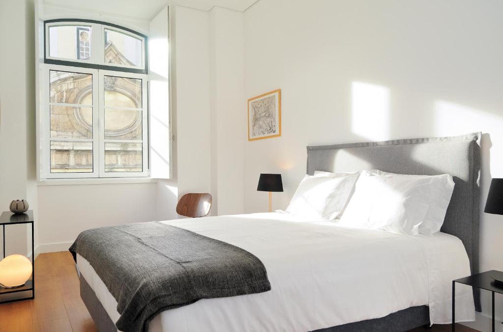a white bedroom with a large bed and a window at Lisbon Serviced Apartments - Baixa Castelo in Lisbon