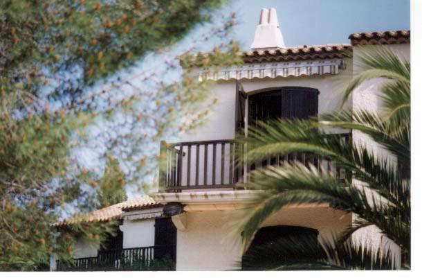 un bâtiment avec un balcon et un palmier dans l'établissement Residence Lou Cigaloun, à La Croix-Valmer