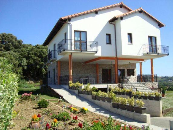 a large white house with flowers in a yard at Posada la Desmera in Isla