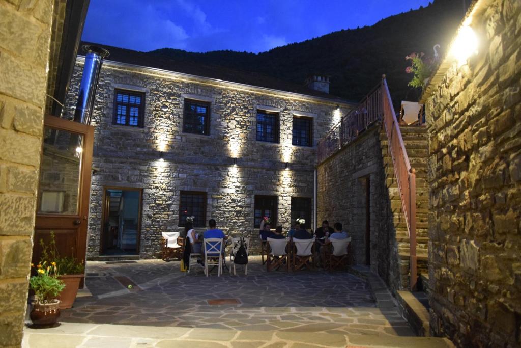 a stone building with people sitting at tables in a courtyard at Argiades in Elati Zagori