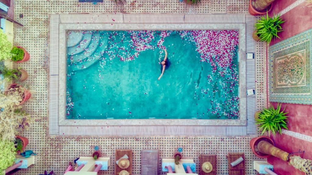 an overhead view of a pool with a surfer in the water at Riad Adahab in Oujda