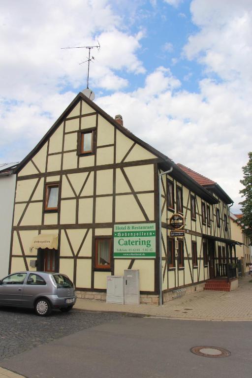 a building with a car parked in front of it at Hotel und Restaurant Hohenzollern in Erfurt