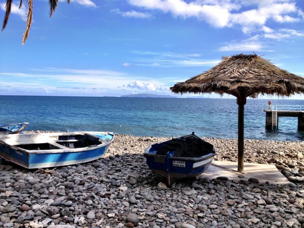 two boats on a rocky beach with an umbrella at Holidays Plaza in Santa Cruz