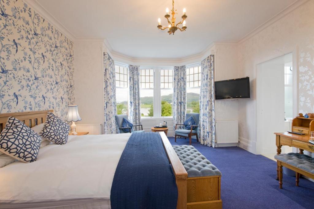 um quarto com uma cama, uma televisão e janelas em Falls of Lora Hotel em Oban