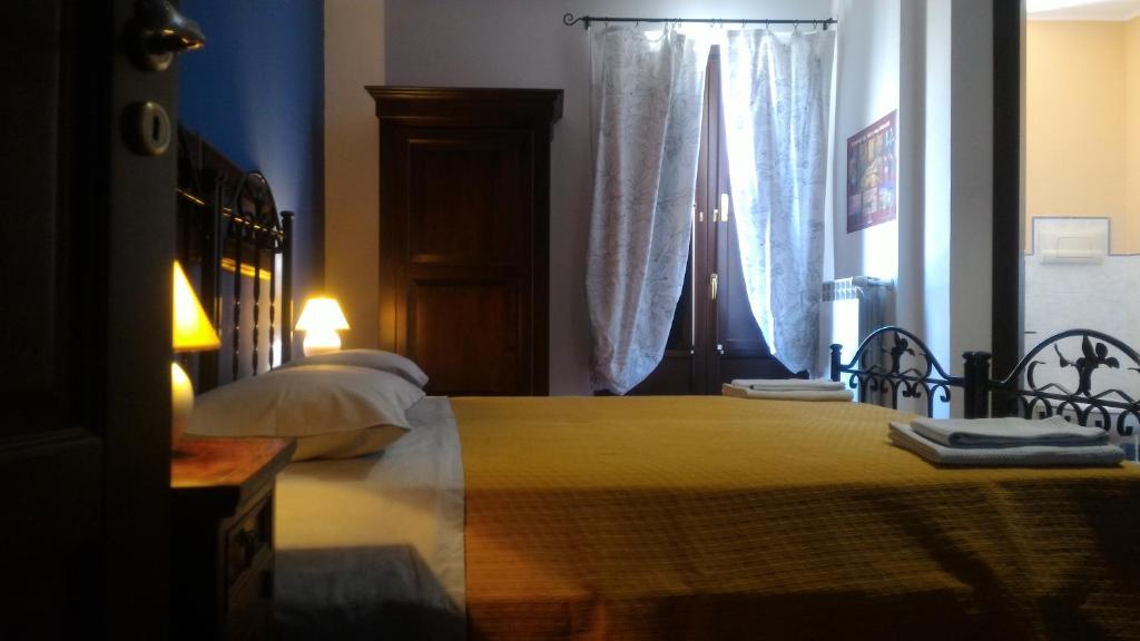 a bedroom with a large yellow bed with a window at B&B Abies in Polizzi Generosa