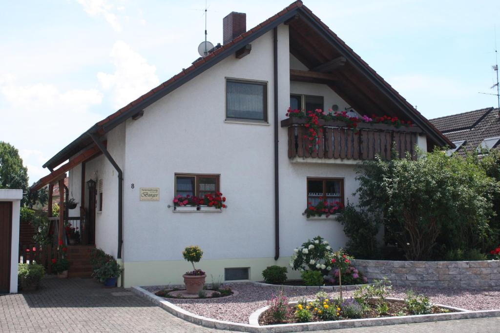 uma casa branca com caixas de flores nas janelas em Ferienwohnung Burger em Sasbach am Kaiserstuhl