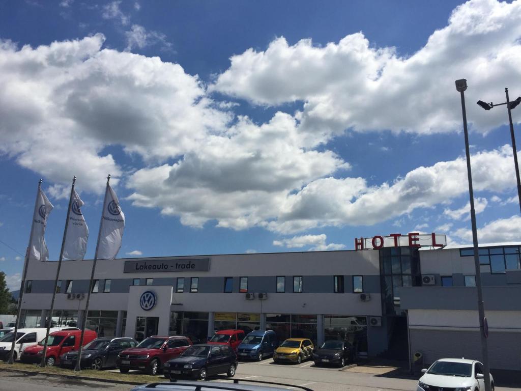 ein Hotel mit Autos auf einem Parkplatz in der Unterkunft Garni Hotel Lake in Čačak