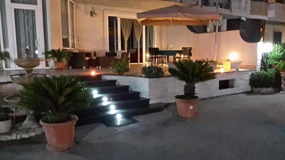 un hall avec des escaliers et des plantes en pot dans un bâtiment dans l'établissement villa lucia, à Mondragone