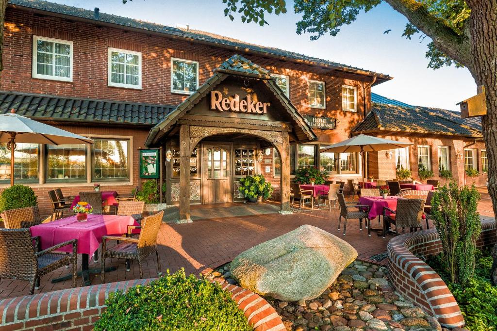 un restaurant avec des tables et des chaises en face d'un bâtiment dans l'établissement Landgasthof Redeker, à Haselünne