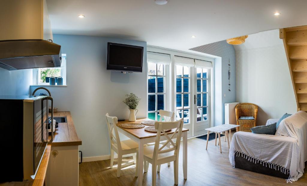 a kitchen and living room with a table and chairs at Slapen aan de Bosweg in Zoutelande