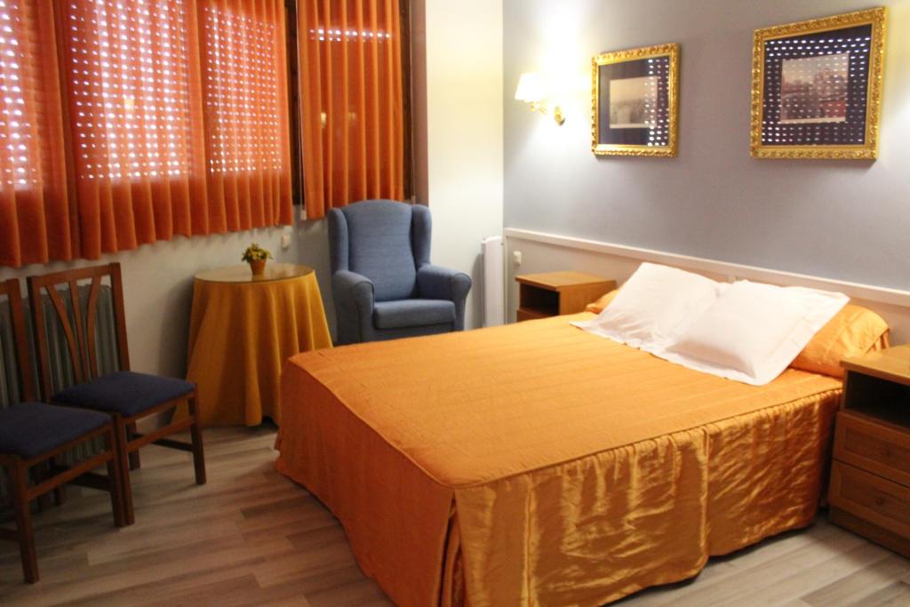 Habitación de hotel con 1 cama y 2 sillas en Hostal Montserrat, en Tona
