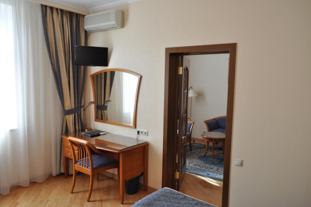 a hotel room with a desk and a mirror at Ozerkovskaya Hotel in Moscow