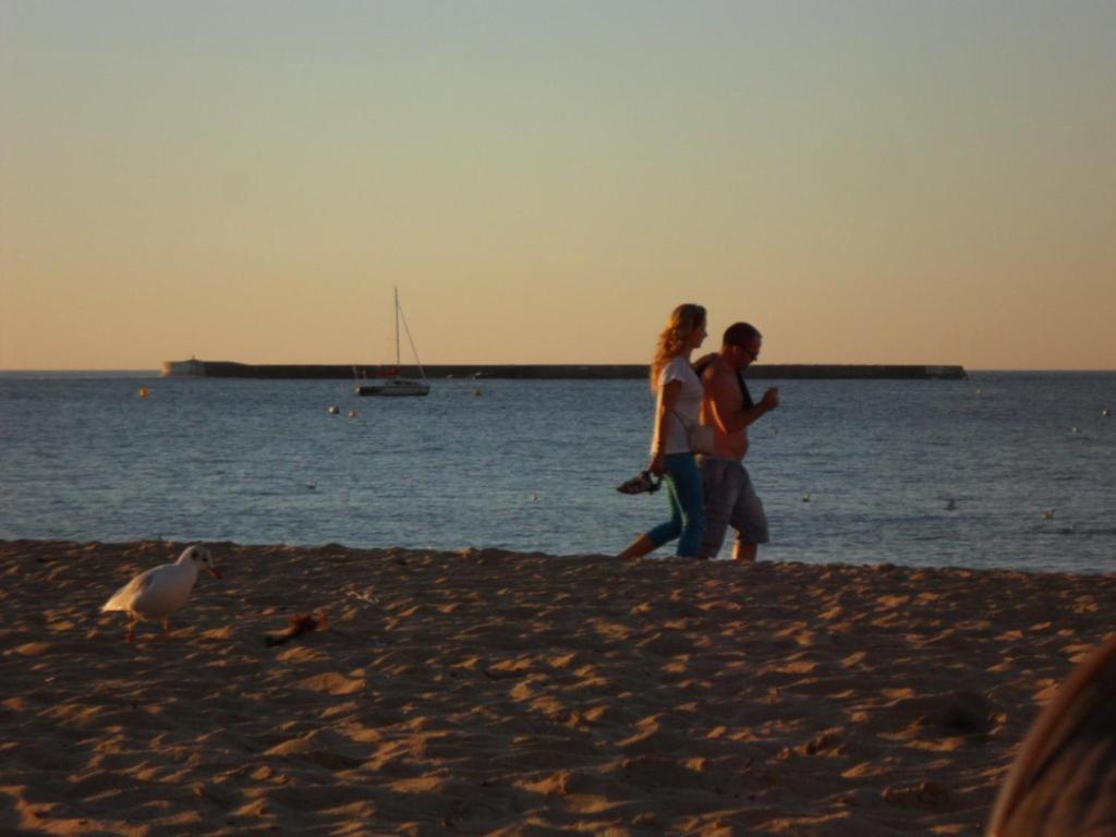 two people walking on the beach near the water at Toki Alai in Saint-Jean-de-Luz